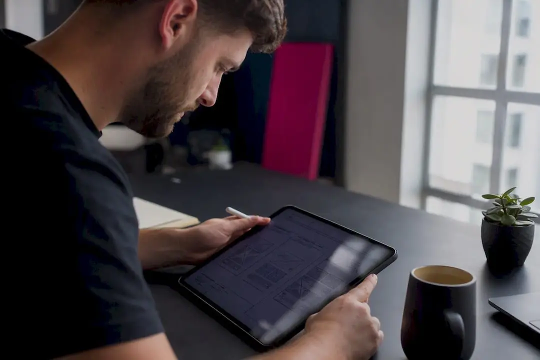 Mãos a trabalhar num tablet com um modelo de wireframe