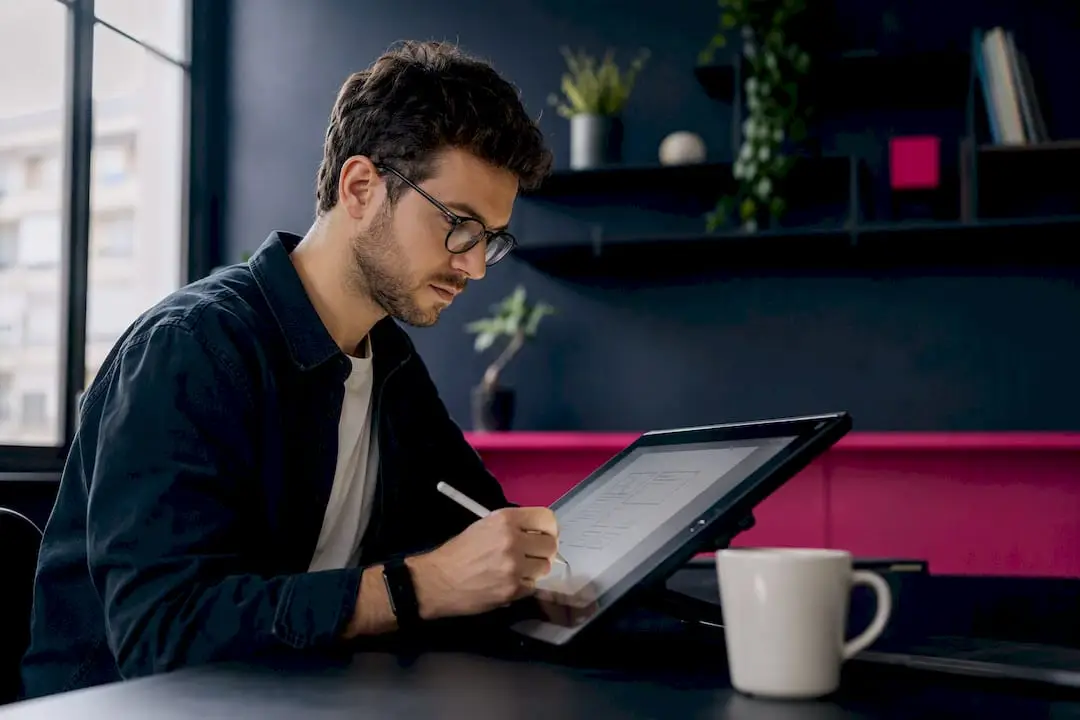 Mãos a desenhar o esboço de um wireframe num tablet