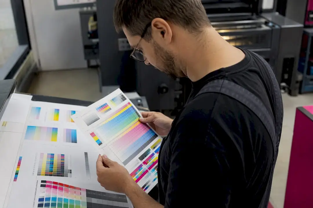 Técnico a segurar folha de teste de impressão CMYK