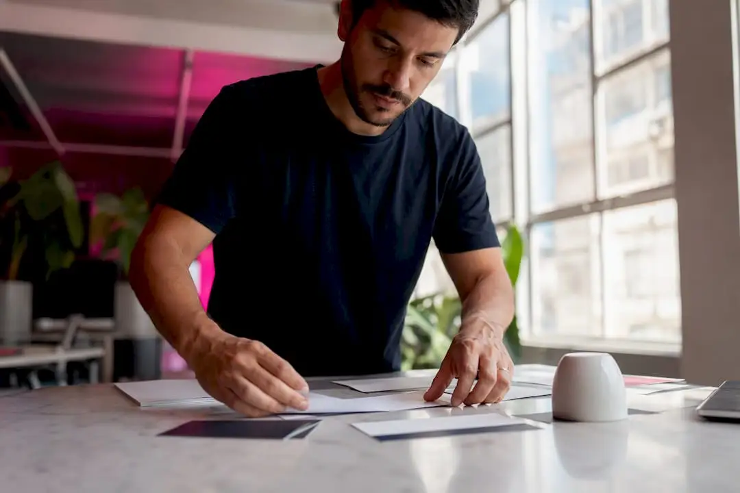 Mãos a organizar materiais para comunicado de imprensa sobre a mesa