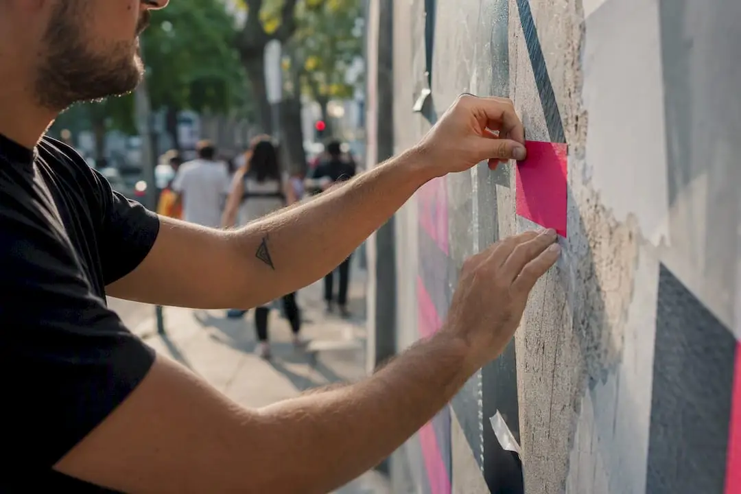 Mãos a aplicar fita adesiva num espaço urbano